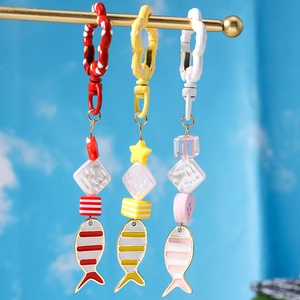 Close-up of enamel goldfish keychains with star beads and floral metal clasps