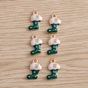 Close-up of green and white enamel Christmas sock charms for DIY jewelry making