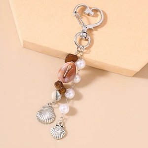 Détail du fermoir en cœur avec perles, coquillages naturels et breloques marines