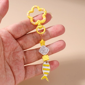 Detail of a handmade keychain with yellow star beads and a striped goldfish pendant charm