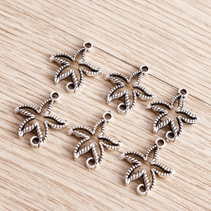 Macro view of six vintage silver alloy leaf pendants with rings on a wooden surface