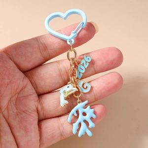 Detailed view of sea-themed keychain featuring blue charms and 2026 digital pendant