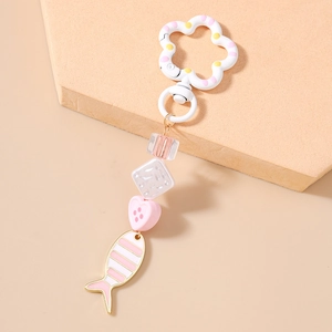 Detail of flower clasp and striped fish pendant keychain charm in pink and white