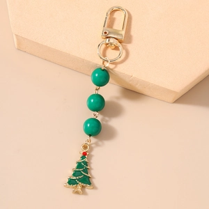 Detail of green beaded Christmas tree keychain with golden clasp for festive bags
