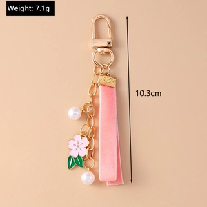 Detail view of pink cherry blossom keychain with velvet ribbon and size markers