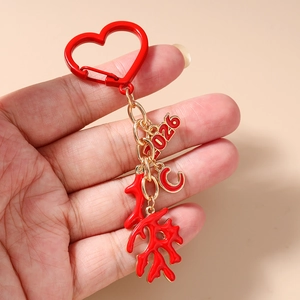 Detail of red enamel 2026 number and coral charm keychain with gold finish