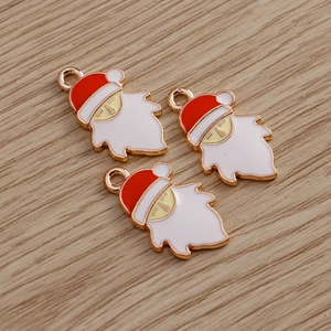 Detailed view of three Santa Claus alloy pendants with red enamel and gold trim