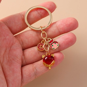 Porte-clés doré avec renard en pierre rouge, sac de fortune et pièce porte-bonheur