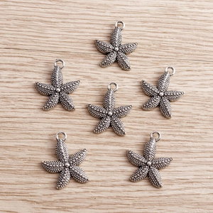 Detail of vintage silver starfish charms with textured surface for jewelry making