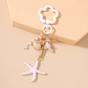 Détail d'un porte-clés thème marin avec étoile de mer rose, hippocampe et perles