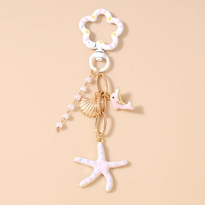 Détails d'un porte-clés marin avec perles, dauphin rose et pendentifs en forme d'étoile de mer