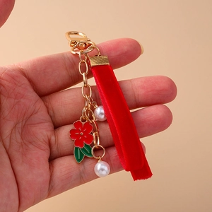 Floral keychain with red flower charm, white pearls, and long velvet ribbon on gold metal chain
