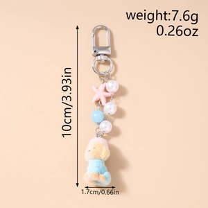 Detail view of plush puppy keychain with pearls and size measurements in inches and cm