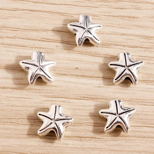 Macro shot of silver starfish beads with intricate textures for DIY jewelry making