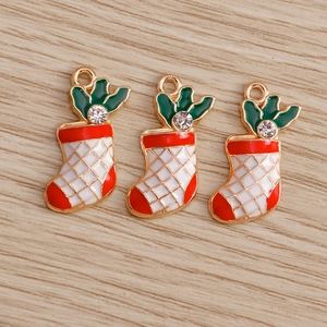 Detailed view of three festive Christmas sock pendants with enamel and zircon for jewelry DIY
