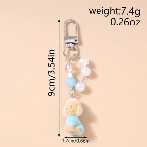 Detail of plush dog keychain with pearl beads, dimensions 9cm by 1.7cm in macro view