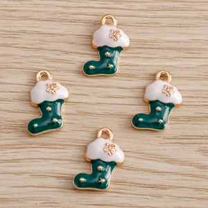 Macro detail of four Christmas stocking pendants with green enamel and gold star patterns