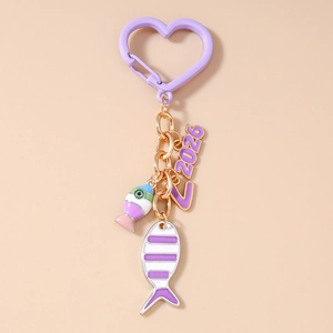 Detail of purple fish keychain featuring heart carabiner and 2026 number charm