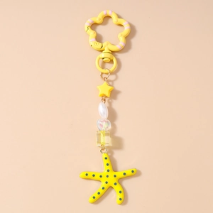 Detail van de gele zeester sleutelhanger met blauwe stippen en een bloemvormige sluiting