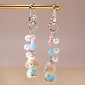 Detailed close-up of poodle plush keychains with pearl beads and starfish charms