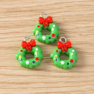 Close-up of green resin Christmas wreath charms with red bows and colorful dots for DIY jewelry