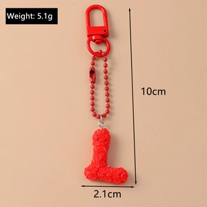 Detail of red letter L keychain featuring 3D rose flower texture and metal clasp
