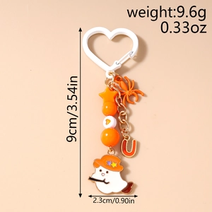 Detail view of Halloween ghost keychain with orange spider and letter U charm for bags