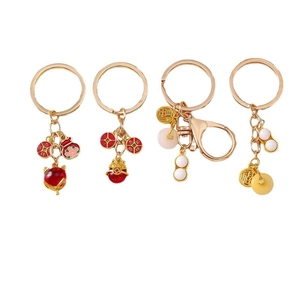 Quatre porte-clés chinois en pierres précieuses avec breloques renard, cacahuète et pièces d'or