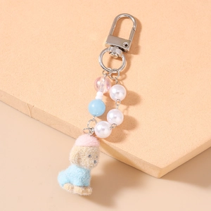 Close-up of pearl bead keychain featuring a plush teddy dog charm with a pink hat