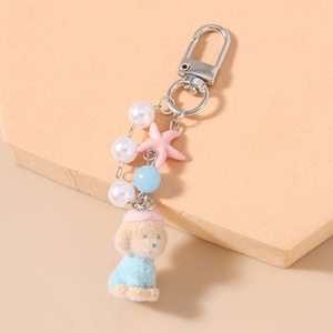 Detail of beaded keychain with plush puppy charm starfish pendant and pearl accents