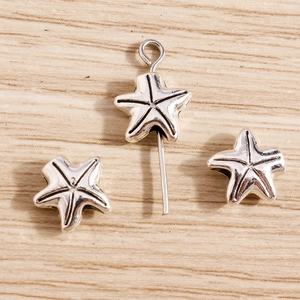 Detailed view of starfish charms in vintage silver alloy for DIY jewelry making