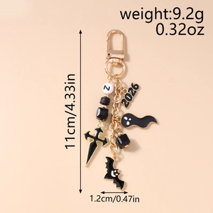 Detail of Halloween keychain with black enamel bat and ghost charms on gold chain