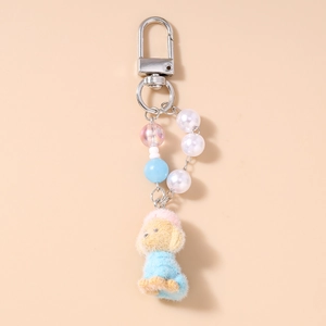 Detail of plush poodle keychain with colorful pearl beads and a silver metal clasp
