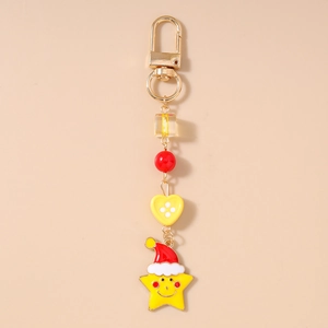 Detail of a festive keychain with a smiling yellow star wearing a red Christmas hat