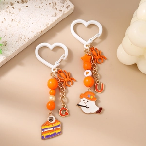 Halloween keychain with spider, ghost charms, and orange beads on a white heart carabiner