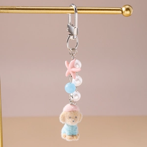 Detail of cute bear keychain with pearls and pink star charm on metal display stand
