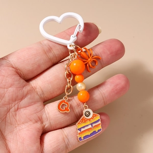 Detail of Halloween keychain featuring orange spider charm and eye cupcake pendant