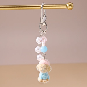 Close-up of plush puppy keychain with colorful pearls and starfish accessory