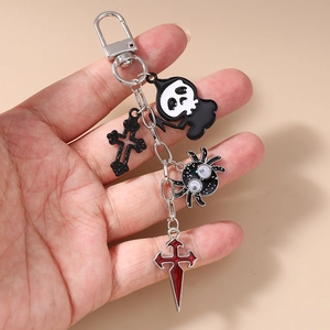 Detail of gothic keychain with grim reaper, baroque cross and spider charms
