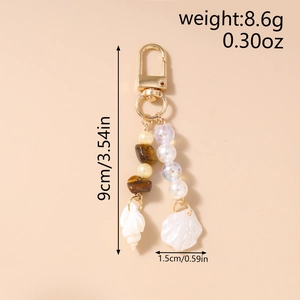 Detailed view of ocean theme keychain with starfish and shell charms in golden finish