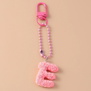 Detail view of pink letter E keychain featuring 3D rose textures and matching lobster clasp