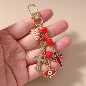 Detail of golden Halloween keychain with red beads, devil eye and 2026 tag charm