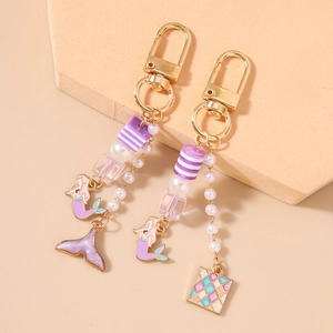 Porte-clés sirène violet avec fermoir doré, chaîne de perles et breloques de queue scintillante