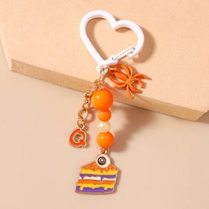 Detail of Halloween keychain with orange spider, letter Q charm, and eye cake pendant