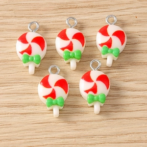 Macro view of 5 red and white lollipop resin pendants with green bows and silver hooks