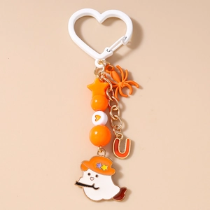 Detail of Halloween keychain featuring orange spider and cartoon ghost with starry hat
