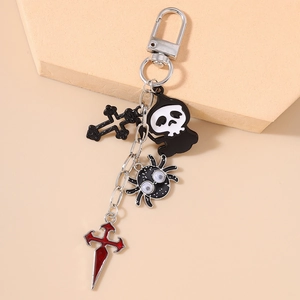 Close-up of Halloween keychain featuring a skull, spider, and black cross pendants
