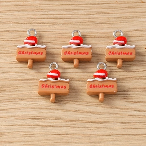 Detailed view of Christmas signpost charms with silver loops on wooden background