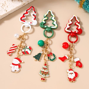 Trois porte-clés de Noël avec pendentifs Père Noël et Bonhomme de neige sur fond beige