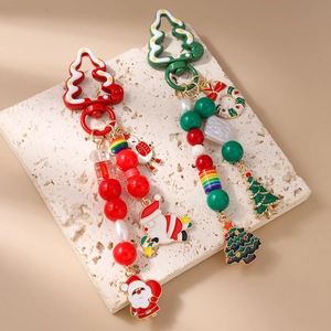 Porte-clés de Noël perlé avec charmes Père Noël, sapin et perles sur fond en pierre